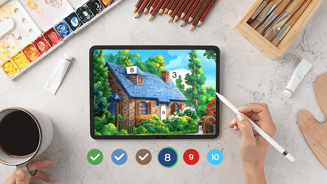 A person with coffee surrounded by physical art supplies uses the app to paint a house with a stylus